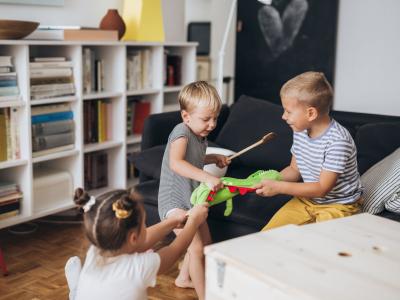 Drei Kindergartenkinder streiten um ein Kuscheltier