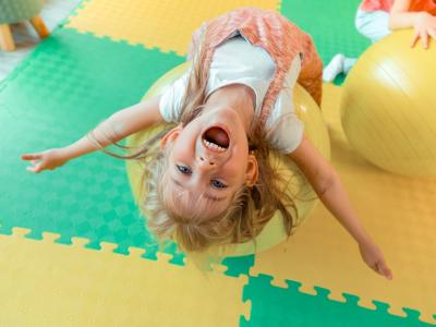 Kind auf Gymnastikball lässt Emotionen freien Lauf