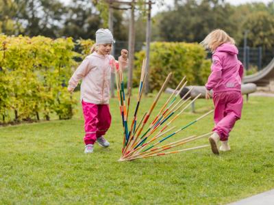 Kindergratenkinder machen Bewegungsspiele im Garten