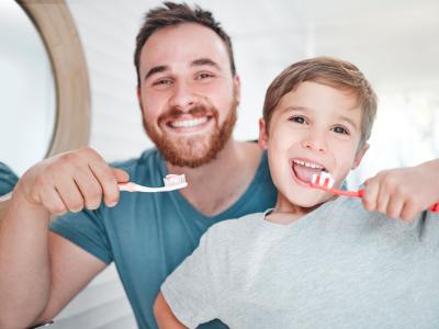 Vater putzt mit Sohn Zähne und ist damit ein Hygienevorbild