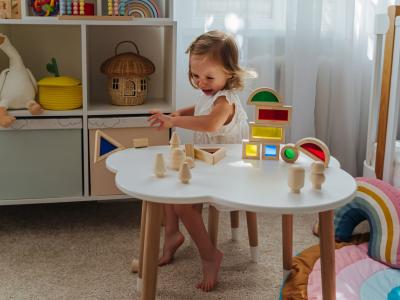 Kind sitzt am Tisch mit Spielsachen und hat Wutanfall
