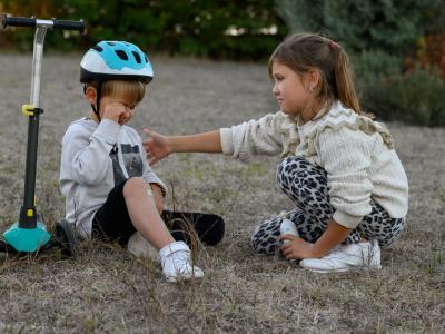 Emotionale Kompetenz Mädchen reagiert empathisch auf kleiner Rollerunfall eines Jungen
