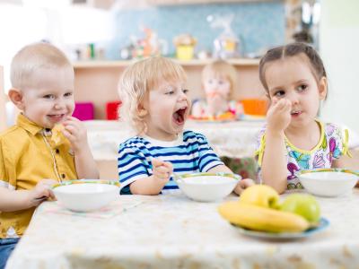 Kinder essen gemeinsam im Kindergarten