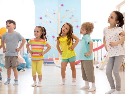 Kindergartenkinder stehen im Kreis und tanzen