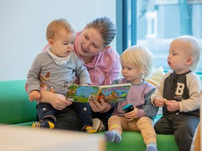 Erzieherin mit einer Gruppe an Krippenkindern