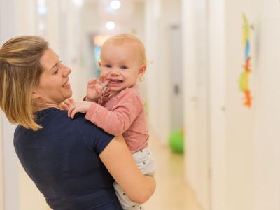 Kinderkrippen Kind im Arm von Erzieherin der Wichtel Akademie Kita