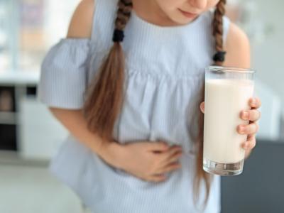 Kind mit Laktoseintoleranz trinkt ein Glas Milch