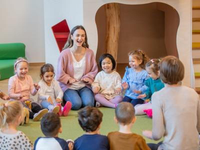 Pädagogische Fachkraft im Morgenkreis mit Kindern