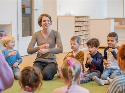Erzieherin singt mit Kindern im Morgenkreis