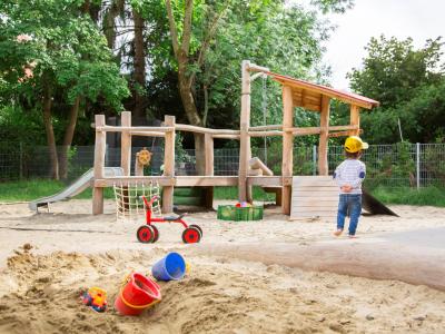 Kindergartenkind spielt im Garten der Kita