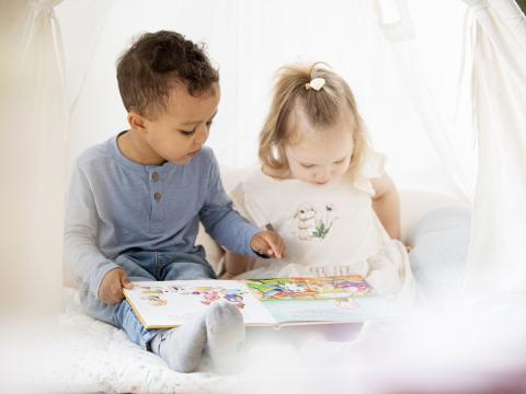Kindergartenkinder lesen gemeinsam ein Buch