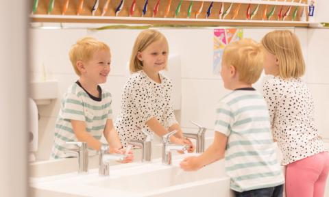 Kinder waschen sich die Hände in der Kita