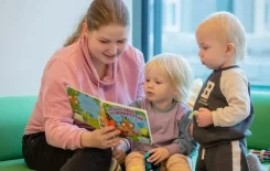 Gute Erzieherin liest ein Buch mit Kind