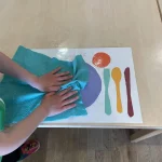 Kind macht sein Platzset sauber